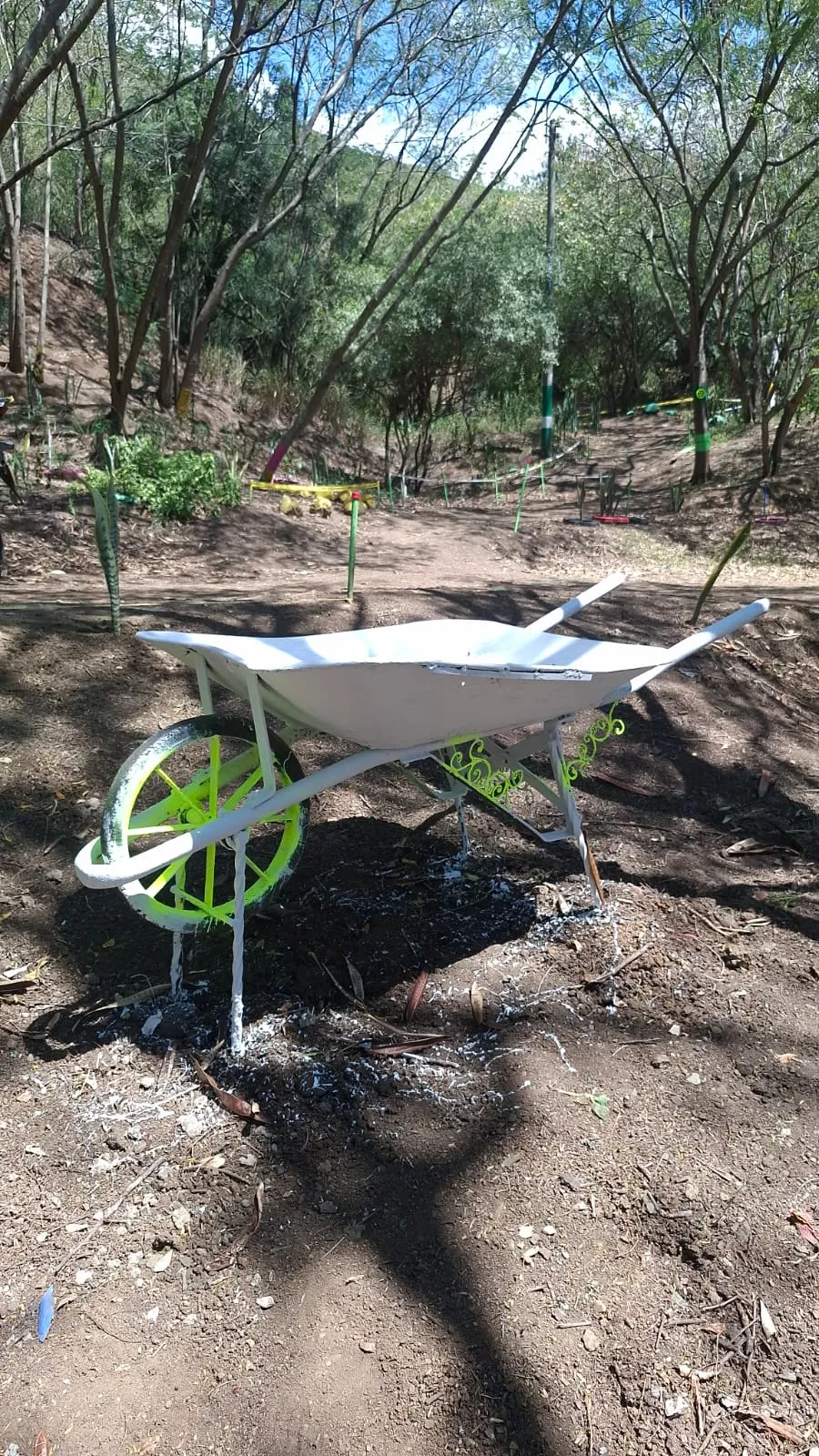 Carretilla reciclada y pintada como jardín decorativo en la pista de ciclomontañismo