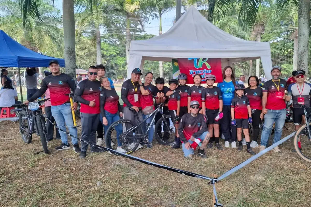 El equipo completo del Club Trocha y Ruta con sus familias y bicicletas en la carpa del club durante una válida de la Copa Valle