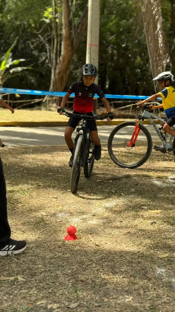 Jostin Villamizar detenido sobre su bicicleta junto a un cono en el circuito de gymkanas, con otro corredor detrás de la cinta