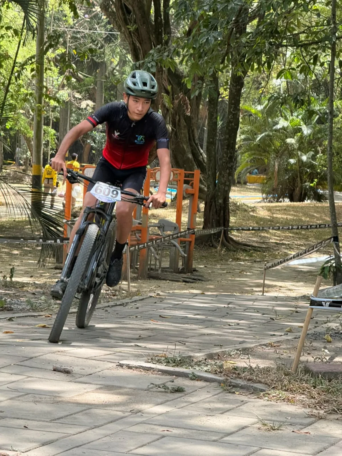 Samuel Ortiz (609) rueda inclinado sobre su bicicleta por un tramo adoquinado del circuito de XCO en el Bosque Municipal de Palmira