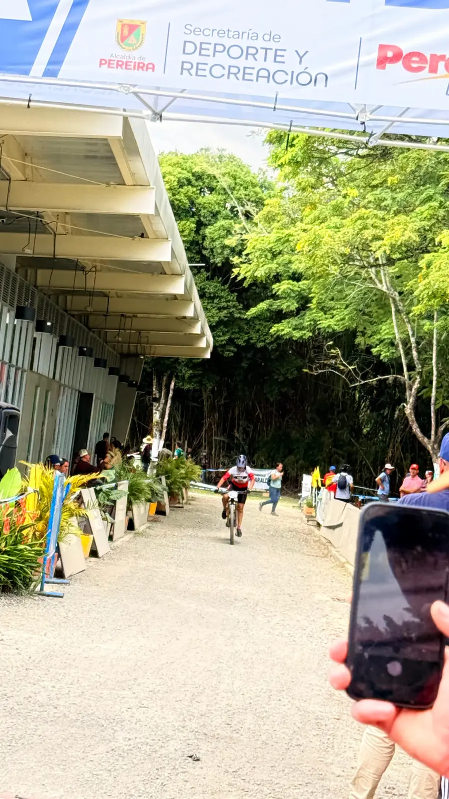 Isabel Quiñónez llega en su bicicleta bajo el pórtico de meta del Nacional MTB 2026, con la pancarta de la Secretaría de Deporte y Recreación de Pereira de fondo